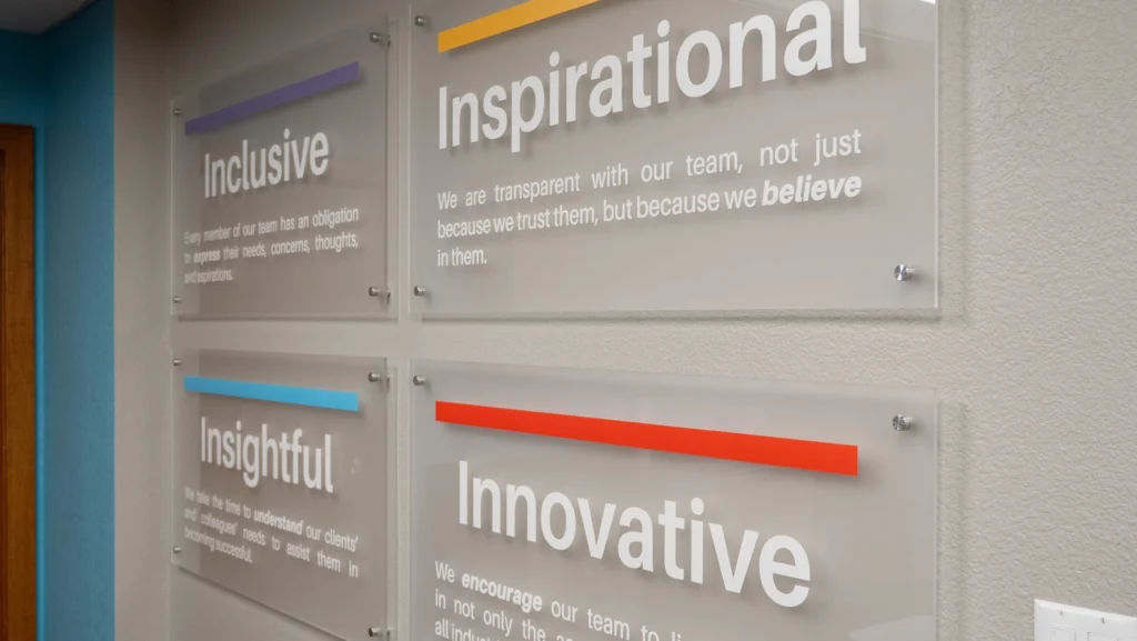 Four signs that say Inclusive, Inspirational, Insightful, and Innovative with Vesta's related mission statement beneath them.