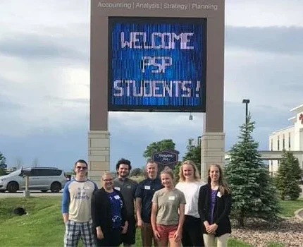 Students taking a picture by digital sign